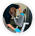 man cleaning gym equipment
