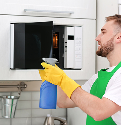 man cleaning microwave
